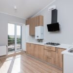 Een moderne keuken met spuitverf afgewerkte keukenkasten in frisse kleuren.