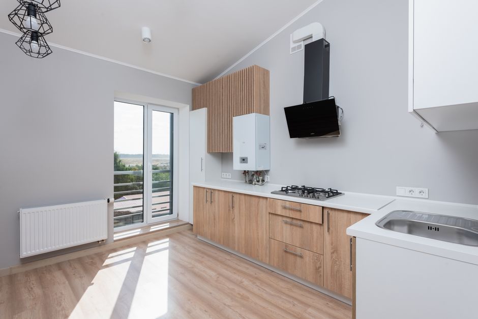 Een moderne keuken met spuitverf afgewerkte keukenkasten in frisse kleuren.